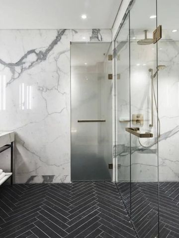 Luxuriöses Badezimmer mit Marmorwänden und geräumiger Dusche