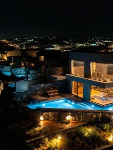 Luxuriöse Villa bei Nacht mit beleuchtetem Pool und Blick auf die Stadt