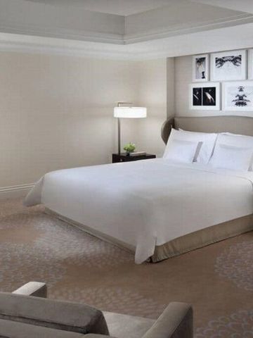 Geräumiges Hotelzimmer mit Doppelbett und stilvollen Kunstwerken an der Wand