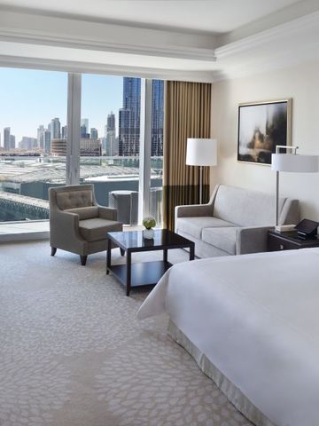 Helles Hotelzimmer mit Panoramafenstern und Sicht auf die Stadt