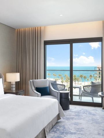 Hotelzimmer mit Balkon und Meerblick durch große Fenster