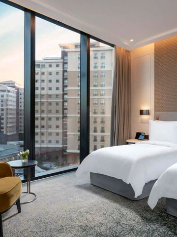 Doppelzimmer mit großen Fenstern und Stadtblick