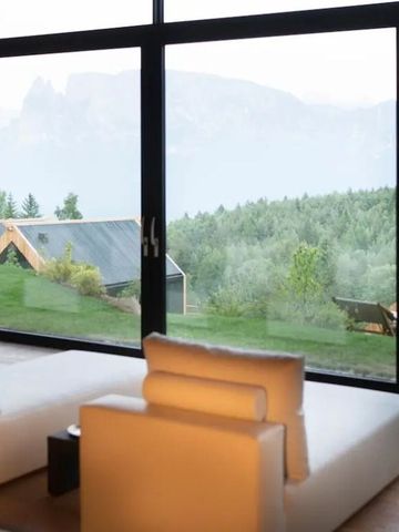 Großes Panoramafenster mit Blick auf grüne Landschaft und Berge