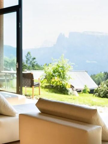 Helle Lounge mit weiter Aussicht auf Berge und grüne Landschaft