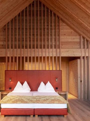 Gemütliches Zimmer mit Holzdekor und großem Bett in der Adler Lodge Ritten.