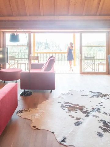 Wohnbereich mit modernen Möbeln und Bergblick auf der Terrasse in der Adler Lodge Ritten.