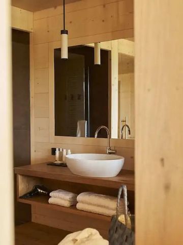 Stilvolles Badezimmer mit Waschbecken und Holzdetails in der Adler Lodge Ritten.