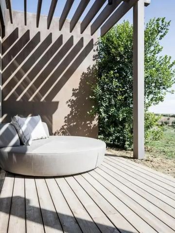 Holzterrasse mit runder Liege und Blick auf Landschaft