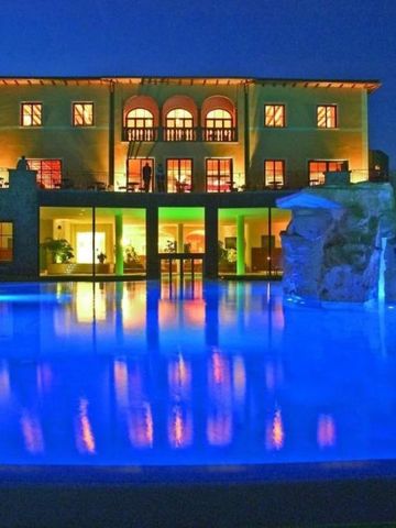 Hotelansicht mit beleuchtetem Pool bei Nacht