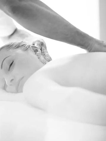 Entspannte Frau erhält eine Rückenmassage im Spa