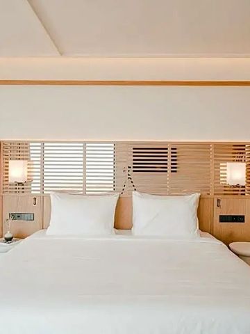 Helles Hotelzimmer mit großem Doppelbett und stilvollem Interieur