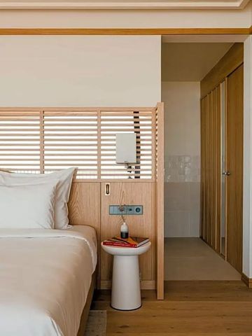 Eckdetail eines stilvoll eingerichteten Hotelzimmers mit Holzjalousie