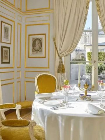 Eleganter Essbereich mit goldenen Details und Blick auf einen Garten.