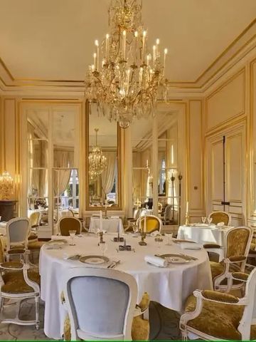 Großer runder Tisch in luxuriösem Raum mit Kronleuchter.