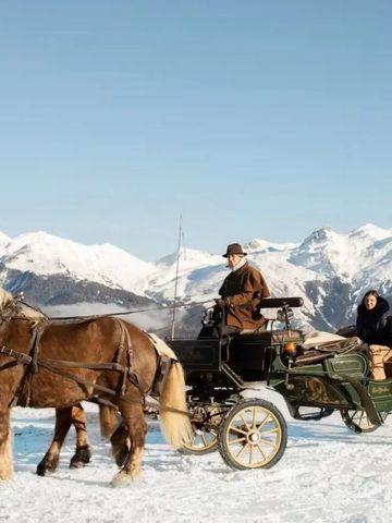 Pferdekutsche vor schneebedeckten Bergen mit blauen Himmel