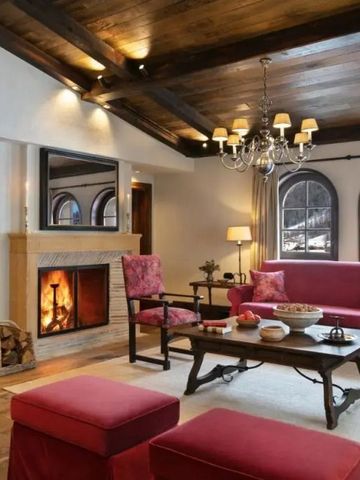 Gemütliches Wohnzimmer mit Kamin und roten Sofas