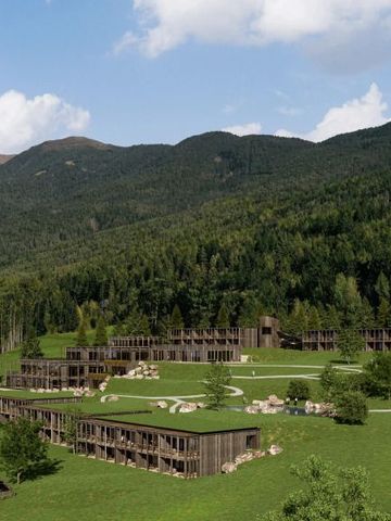 Moderne Hotelarchitektur eingebettet in grüne Landschaft mit Bergen im Hintergrund