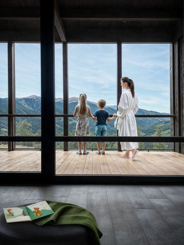 Familie auf Balkon mit Blick auf Berglandschaft
