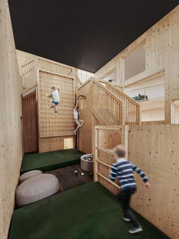 Kinder klettern in einem hölzernen Indoor-Spielbereich
