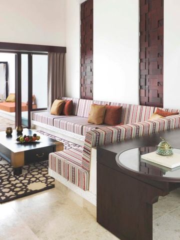 Luxuriöses Wohnzimmer mit eleganter Sofalandschaft und Holzakzenten im Resort.