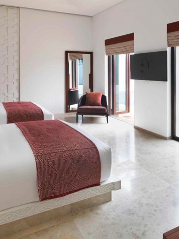 Helles Zimmer mit zwei Betten und direktem Zugang zum privaten Poolbereich.