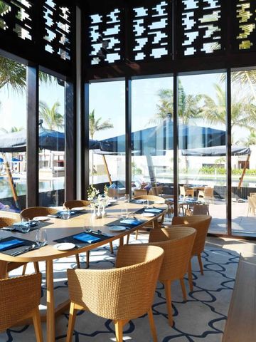 Elegantes Restaurant mit Blick auf Pool und Palmen