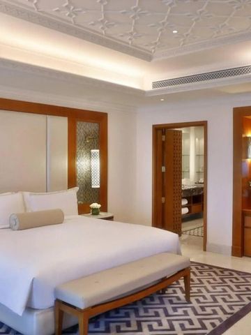 Geräumiges Schlafzimmer in neutralen Tönen mit Blick auf das Badezimmer und Meer