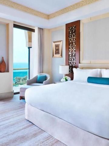 Elegantes Hotelzimmer in hellen Farben mit Meerblick und dekorativer Wandverkleidung