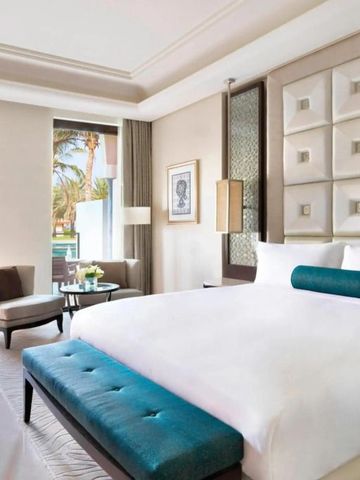 Helles Hotelzimmer mit modernem Design und Blick auf Palmen