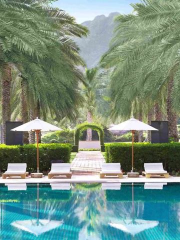 Luxuriöser Poolbereich umgeben von Palmen und Liegen