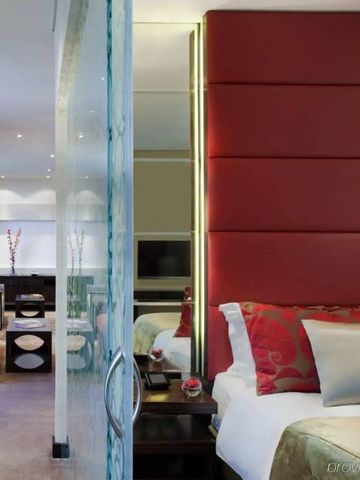 Modernes Dekor im Hotelzimmer mit rotem Akzent und Raumteiler aus Glas