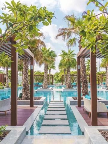 Luxuriöser Poolbereich mit Palmen und eleganten Sitzgelegenheiten im Al Messila Resort.