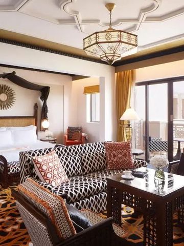 Luxuriöse Suite mit gemütlicher Sitzecke und Zugang zu einem Balkon im Jumeirah Al Qasr