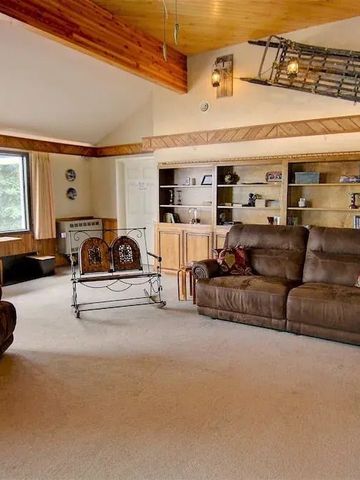 Gemütliches Wohnzimmer mit großen Fenstern und braunen Sofas