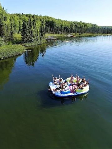 Gruppe von Personen auf einer Schwimmplattform in einem ruhigen See