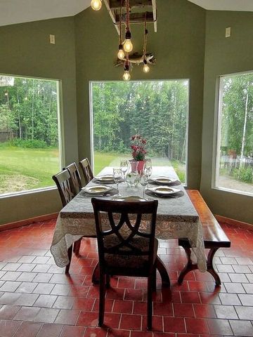 Eleganter Speiseraum mit großem Fenster und Aussicht auf den Wald