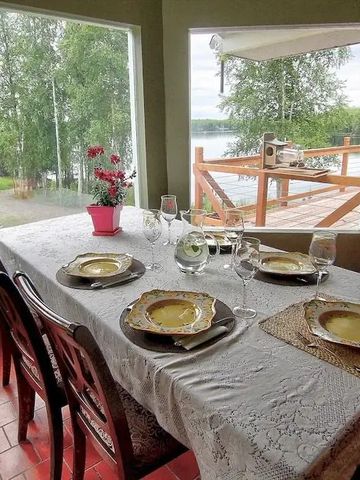Gedeckter Tisch am Fenster mit Blick auf See und Wald