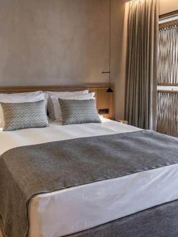 Komfortables Bett mit eleganten Kissen und minimalistischer Dekoration im Hotelzimmer