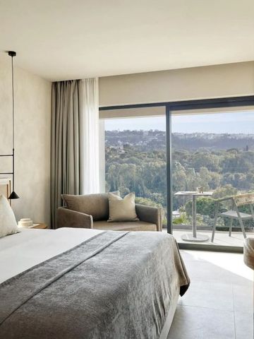 Hotelzimmer mit großem Fenster und Aussicht auf die grüne Landschaft