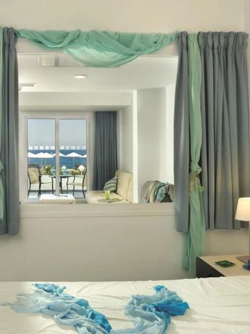 Helles Schlafzimmer mit Meerblick und farbenfrohen Vorhängen