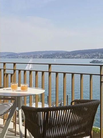 Balkon mit Seeblick und Tisch mit zwei Getränken