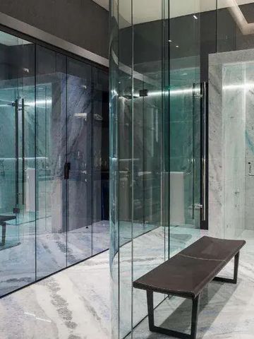 Luxuriöse Sauna mit gläserner Trennwand und Marmorverkleidung