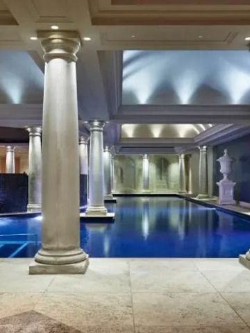 Luxuriöser Innenpool mit beeindruckenden Säulen und sanfter Beleuchtung