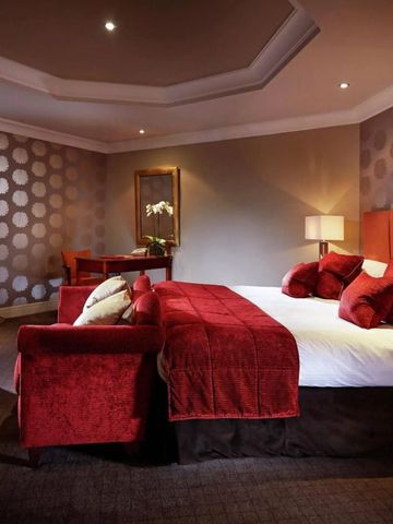 Komfortables Doppelzimmer in warmen Rottönen mit modernem Design