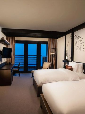 Modernes Hotelzimmer mit zwei Betten und Balkon im Alila Jabal Akhdar mit Blick auf die Berge