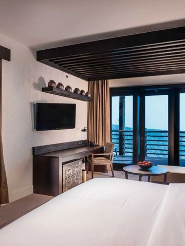 Geräumiges Zimmer mit modernem Dekor und Balkonblick auf die Berge.