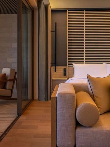 Komfortabler Sitzbereich und Bett in einem Zimmer des Alila Kothaifaru Maldives