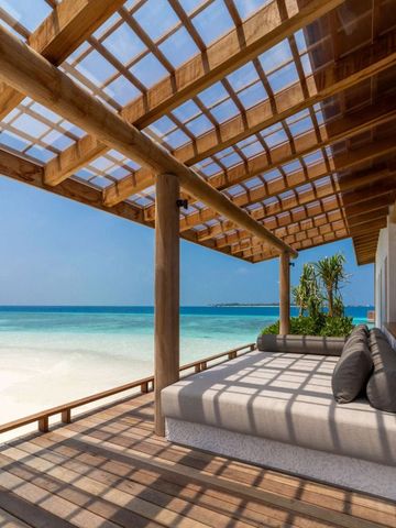 Traumhafte Terrasse mit Liege und Blick auf den weißen Sandstrand und das türkisfarbene Meer