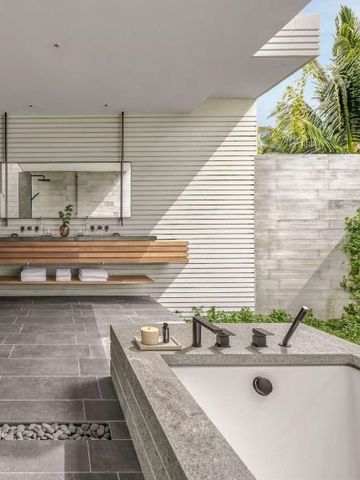 Modernes Bad im Freien mit eleganter Badewanne und grüner Umgebung