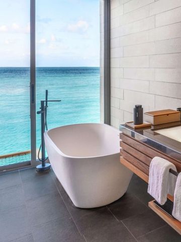 Luxus-Badezimmer mit freistehender Badewanne und Blick auf den Ozean